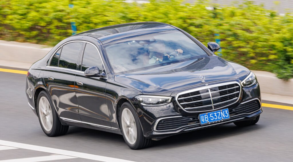 Black Mercedes-Benz S-Class (W223) driving on a road