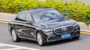 Black Mercedes-Benz S-Class (W223) driving on a road